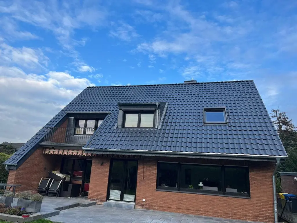 Neu eingedecktes Dach mit Dachgauben bei blauem Himmel